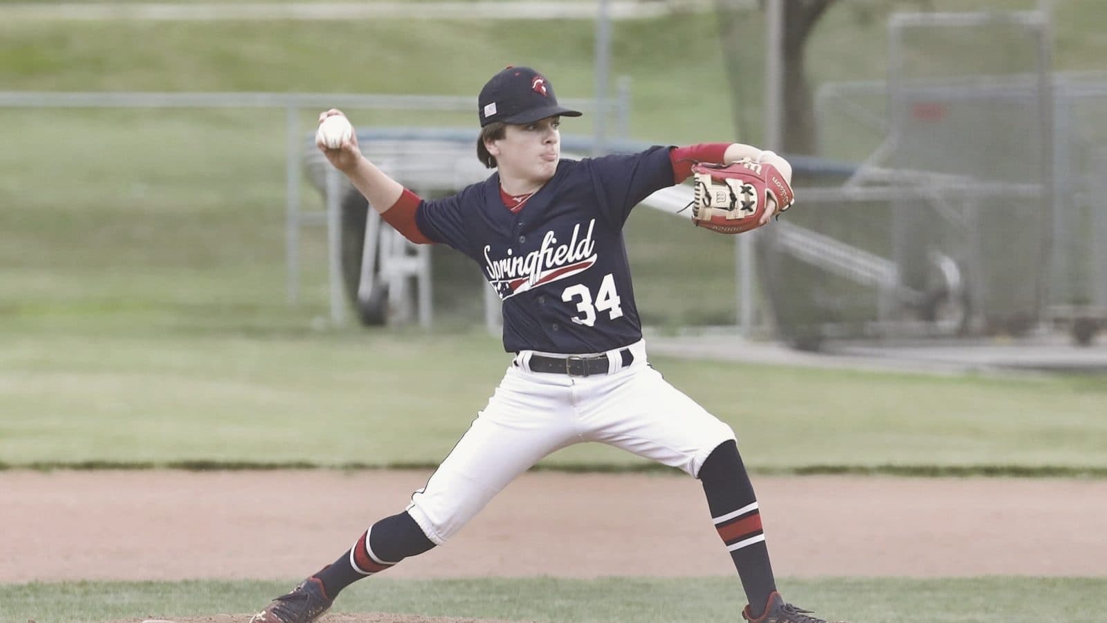 A pitcher mid-windup on the mound